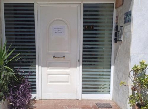 a white door with a sign on it at Angela's Apartment in Chalkida