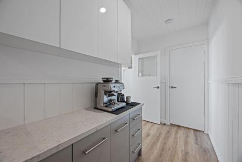a white kitchen with a counter top with a microwave at Stoneleigh Rise - Mansfield - Sleeps 12 in Mansfield