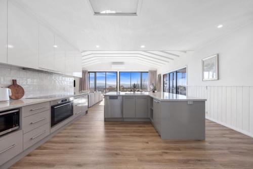a large kitchen with white cabinets and wood floors at Stoneleigh Rise - Mansfield - Sleeps 12 in Mansfield