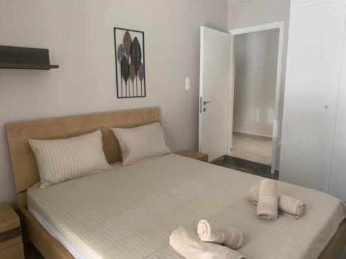 a bedroom with a bed with two towels on it at Eva Apartment in Ermoupoli