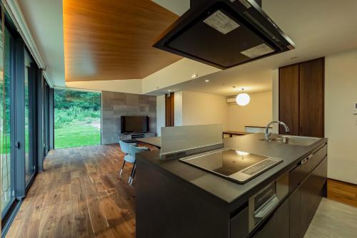 a kitchen with a sink and a large window at 緑と光が包む家 in Nasu
