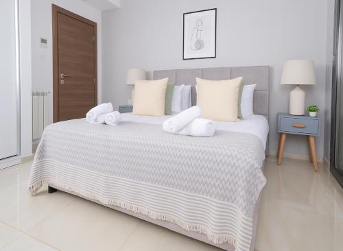 a white bedroom with a large bed with white pillows at Magnifique appartement à Kouba in Kouba