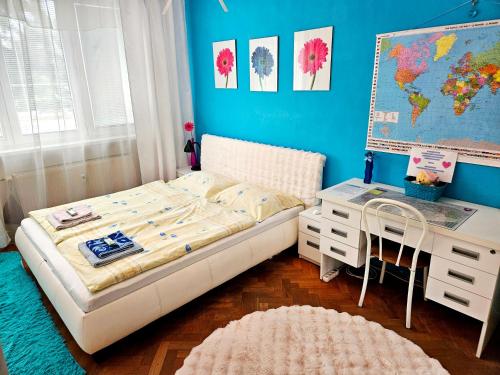 a small bedroom with a bed and a desk at Cozy Blue Apartment Prešov in Prešov
