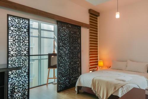 a bedroom with a bed and a sliding glass door at Oasis 2 Masdar City in Abu Dhabi