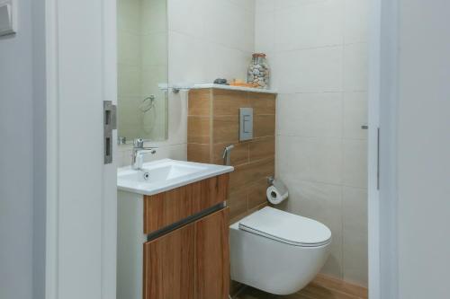 a small bathroom with a toilet and a sink at Oasis 2 Masdar City in Abu Dhabi