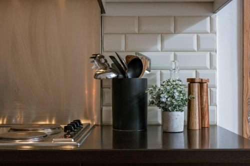 a kitchen counter with a container of utensils on a stove at Huswell - Charming studio in the center of Antwerp in Antwerp