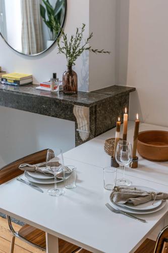a white table with candles and glasses on it at Huswell - Charming studio in the center of Antwerp in Antwerp