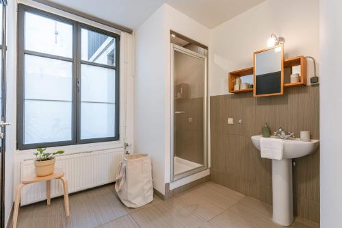 a bathroom with a sink and a shower at Huswell - Charming studio in the center of Antwerp in Antwerp