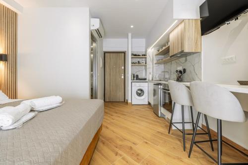 a bedroom with a bed and a kitchen with a counter at Magea Suites in Áyios Andónios