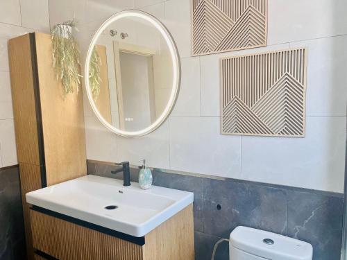 Un baño con lavabo, espejo e inodoro. en Casa La Paz, en Torrevieja