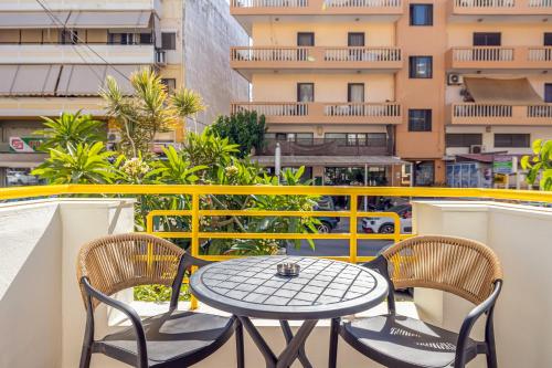 a table and chairs on the balcony of a building at Magea Suites in Áyios Andónios