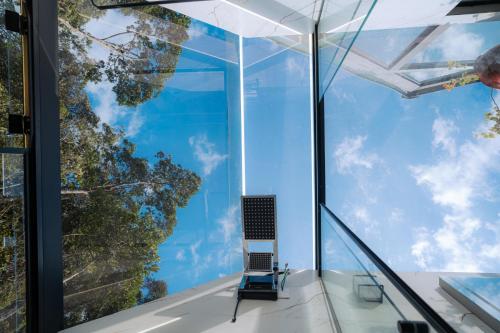 a glass house with a laptop in the window at Cabanas de Zorzi Refúgio na Natureza perto de Floripa in Santo Amaro da Imperatriz