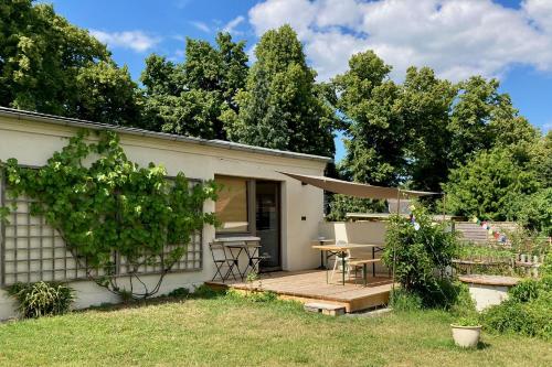 a house with a wooden deck with a table at Charmantes Ferienhaus Wolf Schaefer in Gelbensande