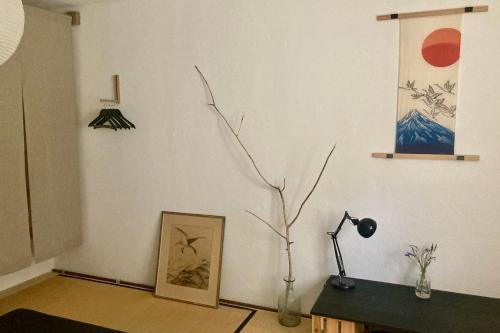 a room with a lamp and a vase with a tree in it at Charmantes Ferienhaus Wolf Schaefer in Gelbensande