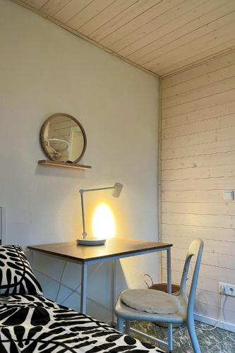 a desk with a lamp and a chair next to a bed at Charmantes Ferienhaus Wolf Schaefer in Gelbensande