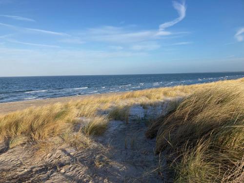 a sandy beach with the ocean in the background at Charmantes Ferienhaus Wolf Schaefer in Gelbensande