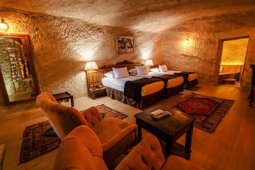 a bedroom with two beds and chairs in a room at Utopia Cave Cappadocia in Urgup