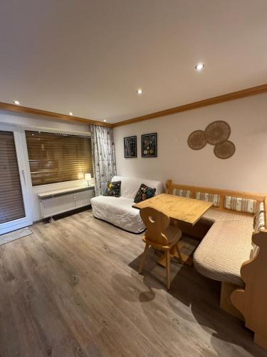 a living room with a couch and a table and a bed at Gemütliche Wohnung mit Bergblick und Terrasse in Obermaiselstein
