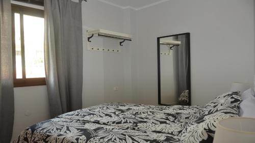 a bedroom with a bed and a mirror and a window at Apt. El Molino 3A in Valle Gran Rey