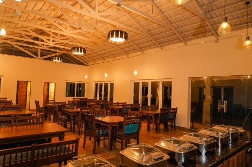 a dining room with tables and chairs in a room at Vishmaa Resort in Madikeri