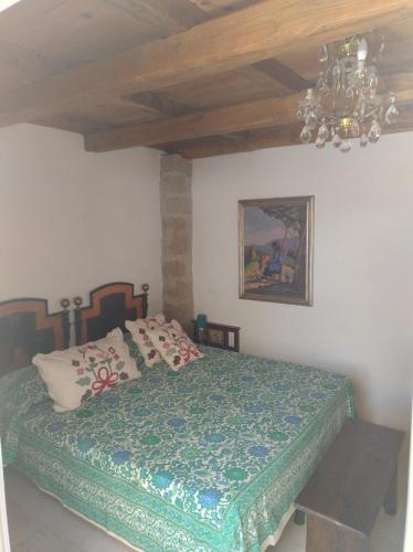 a bedroom with a bed and a chandelier at La Coloniale San Pantaleo in San Pantaleo