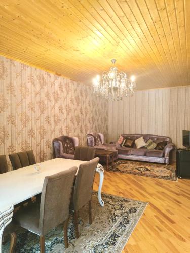 a dining room with a table and a chandelier at İsmayıllı dağın ətəyində kirayə ev in İsmayıllı