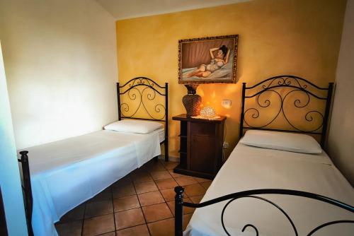 a room with two beds and a painting on the wall at Villa Silmona B&B - Relax nel cuore del Salento in Aradeo