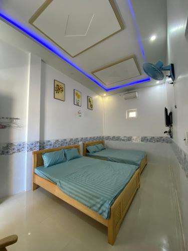 a bedroom with a bed with blue lights on the ceiling at Nhà nghỉ Bá Thành - Lý Sơn in Quang Ngai