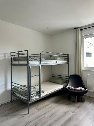 a room with three bunk beds and a chair at Geräumiges Apartment nähe Starlight express & Stadtzentrum in Bochum