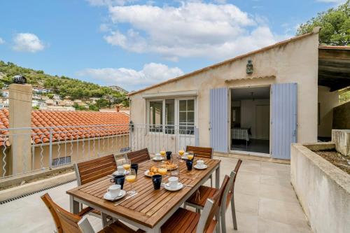 einen Holztisch und Stühle auf einer Terrasse mit Balkon in der Unterkunft Calanque de Niolon, emplacement exceptionnel 1 minute de la mer in Le Rove