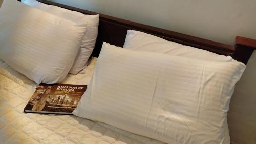 a book sitting on top of a bed with pillows at Tree Nature Resort in Hali Ela