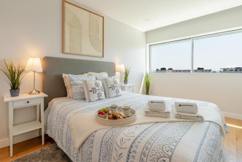 a bedroom with a bed with a bowl of fruit on it at Stylish Home with Balcony & Garage by HostWise in Porto
