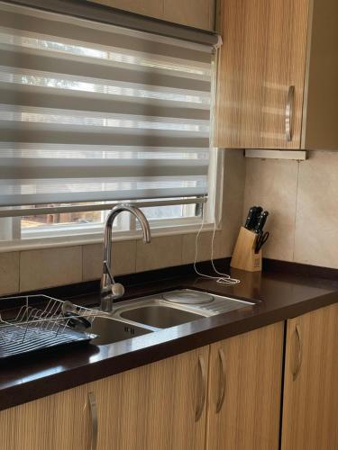 a kitchen with a sink and a window with blinds at Hillview Homes Apartment in Ndola