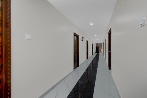a corridor of a building with white walls and ceilings at Super Townhouse Oak Bachupally Medical College Formerly SV Hotels in Lingampalli