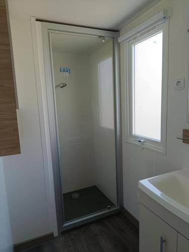 a bathroom with a shower with a glass door at MOBILHOME Margueritte in Lattes