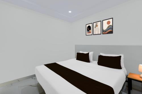 a bedroom with a white bed with black pillows at Super Townhouse Oak Bachupally Medical College Formerly SV Hotels in Lingampalli