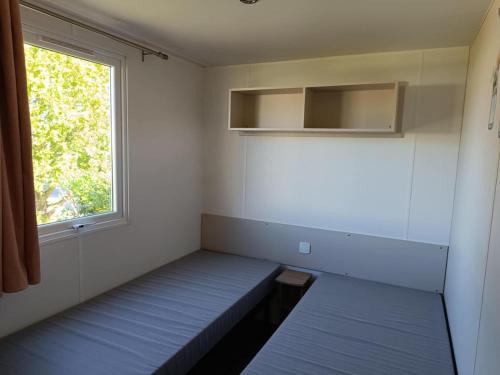a small room with two beds and a window at MOBILHOME Margueritte in Lattes
