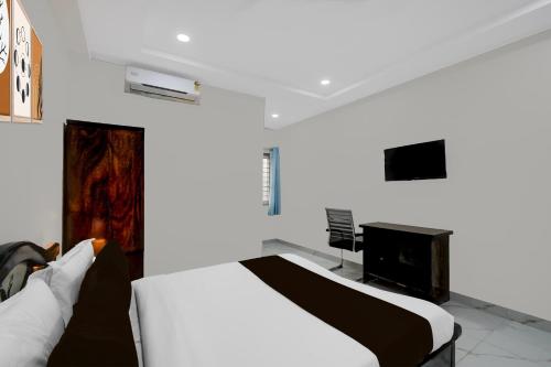a white room with a bed and a tv at Super Townhouse Oak Bachupally Medical College Formerly SV Hotels in Lingampalli