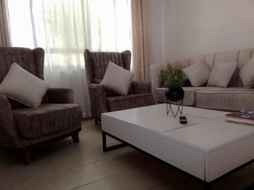 a living room with a couch and two chairs and a coffee table at THE LAGOON RESORT AND Spa in Kutu