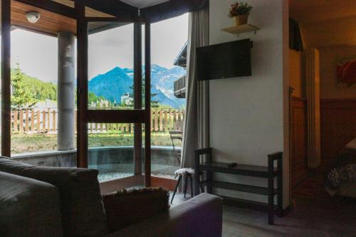 a living room with a large window with a view of a mountain at Shackleton Chalet in Sestriere