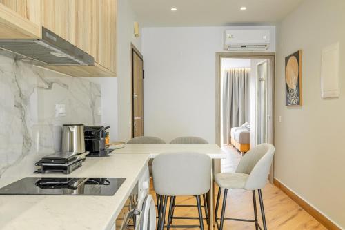 a kitchen with a counter and two stools at Magea Suites in Áyios Andónios