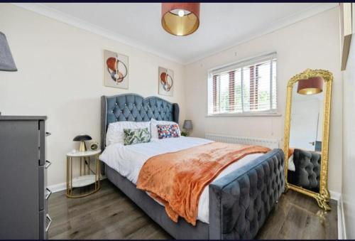 a bedroom with a large bed and a mirror at Luxurious & Central MK in Shenley Church End