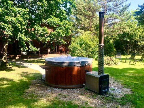 a hot tub and a smoker in a yard at Kibuvitsa Holiday House in Muratsi