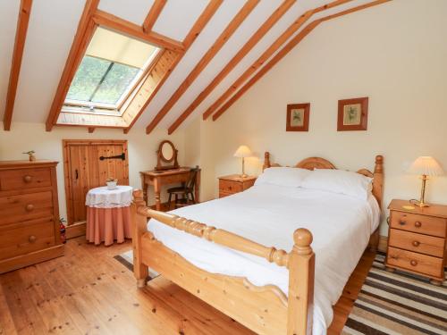 a bedroom with a large bed and a window at Dan Castell Cottage in Llandeilo