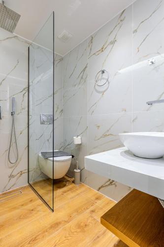 a bathroom with a sink and a glass shower at Magea Suites in Áyios Andónios