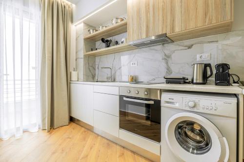 a kitchen with a washer and a washing machine at Magea Suites in Áyios Andónios