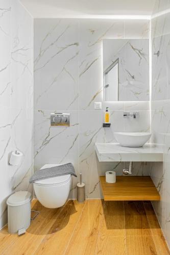 a white bathroom with a sink and a toilet at Magea Suites in Áyios Andónios