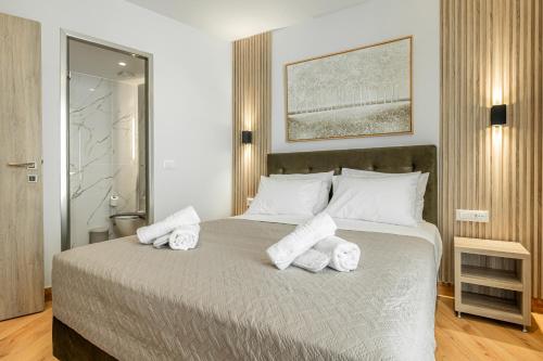a bedroom with a bed with towels on it at Magea Suites in Áyios Andónios