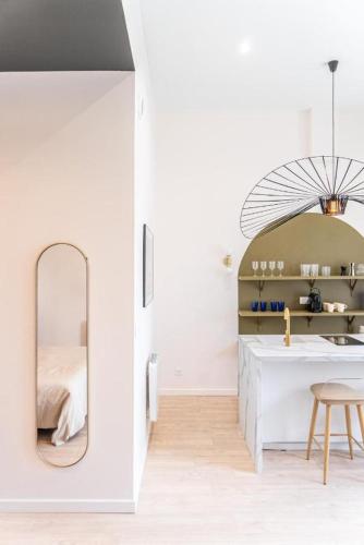 - une chambre blanche avec un miroir et un lit dans l'établissement Cocon Gare Perrache, à Lyon