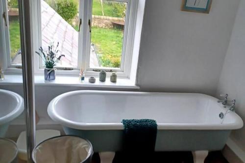 a white bath tub in a bathroom with a window at 3 Bed Cottage-Sleeps 6-Country Views-Pet friendly in Houghton le Spring